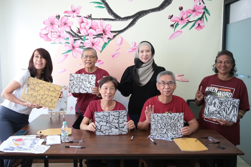 A group holding up the black-and-white doodle panels they completed